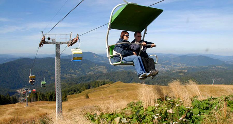 Traveling over autumn Carpathian Mountains on the chair lift