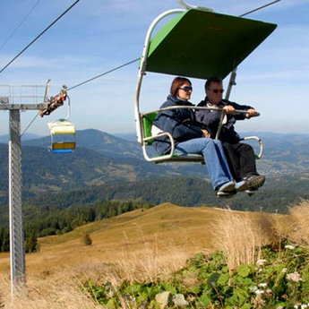 Traveling over autumn Carpathian Mountains on the chair lift
