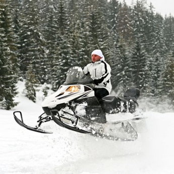 Extreme snowmobiling trip on snow-covered mountain paths