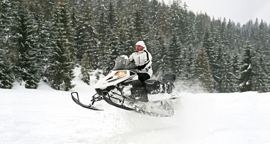 Extreme snowmobiling trip on snow-covered mountain paths